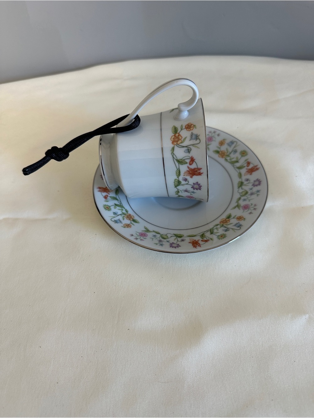 Hanging teacup and saucer birdfeeder floral pattern with gold rim.
